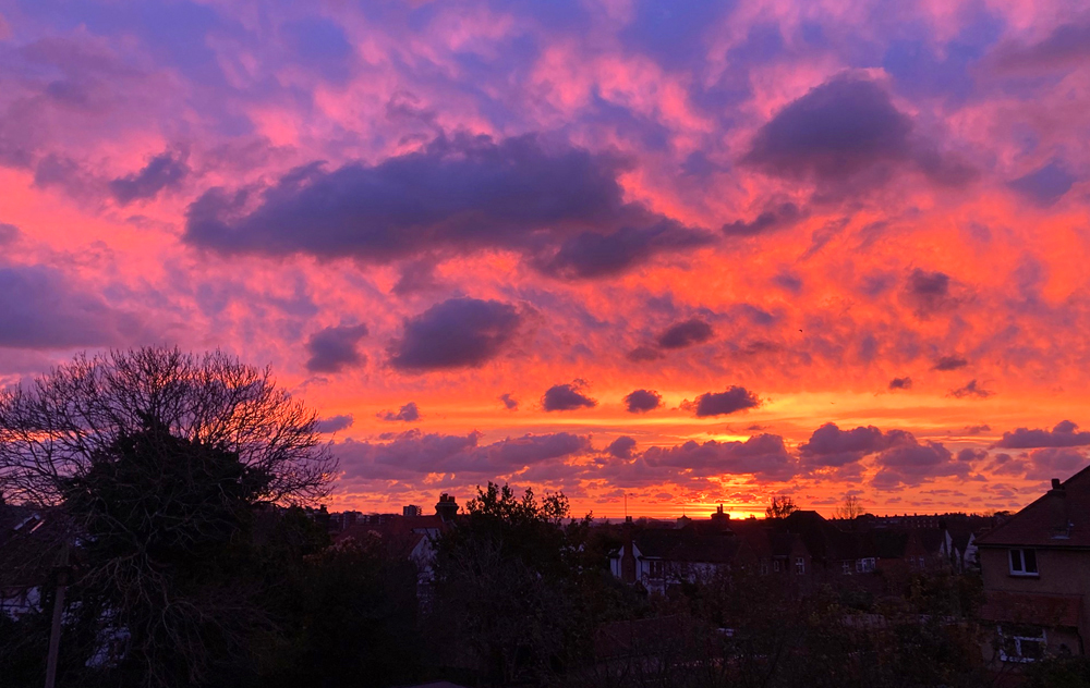 Saturday November 22nd (2025) The sun is about to rise above the sea and houses. width=